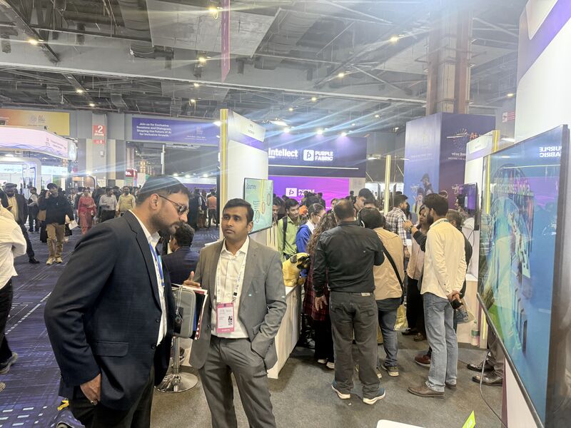 A wide view of the crowded India AI Expo floor at Bharat Mandapam, showing the scale of attendance across the partner halls.